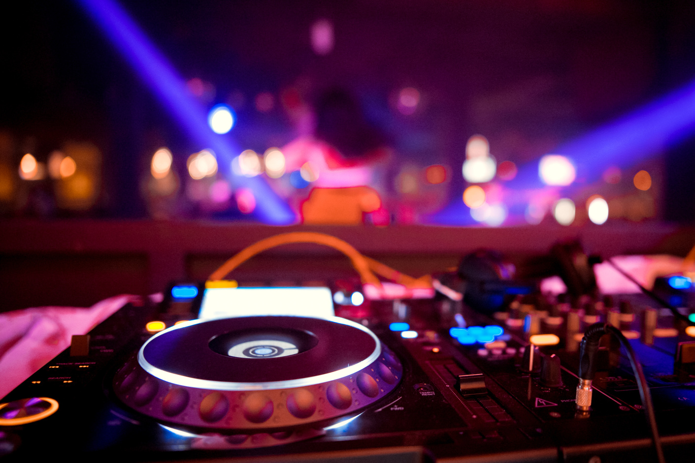 DJ behind the decks in a nightclub. DJ spinning plate. people dancing in a nightclub. disco